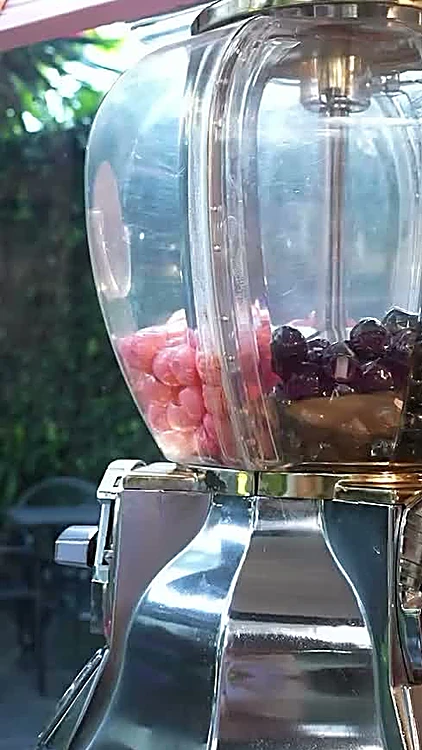 La máquina de bolitas del estudio, llena de bolitas rosas y negras.